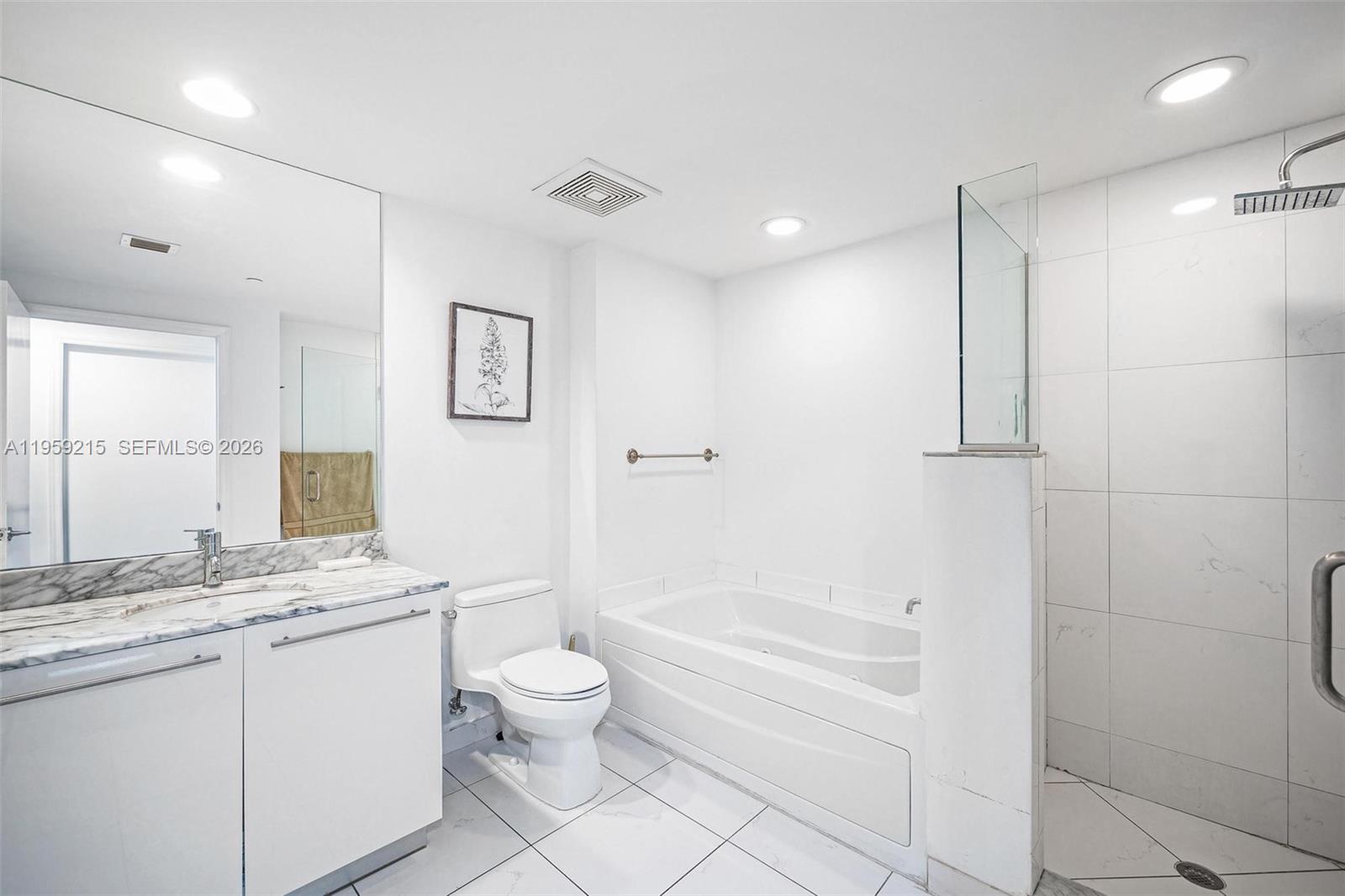 500 Brickell Avenue, Unit 1903 Miami, FL 33131 - Photo 11 of 18 a bathroom with a granite countertop sink a toilet a large mirror and shower