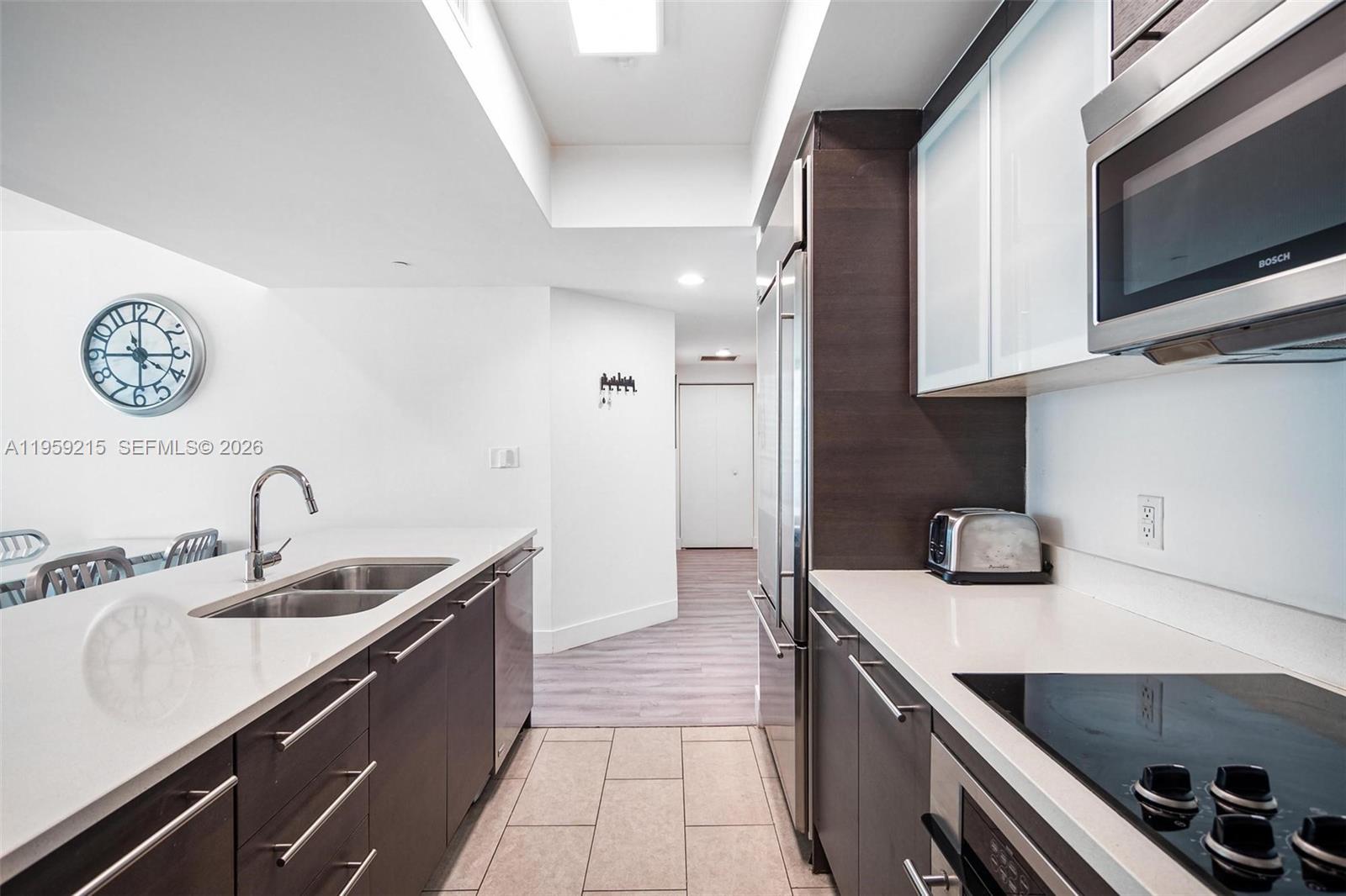 500 Brickell Avenue, Unit 1903 Miami, FL 33131 - Photo 7 of 18 a kitchen with kitchen island granite countertop a sink a stove and a microwave oven