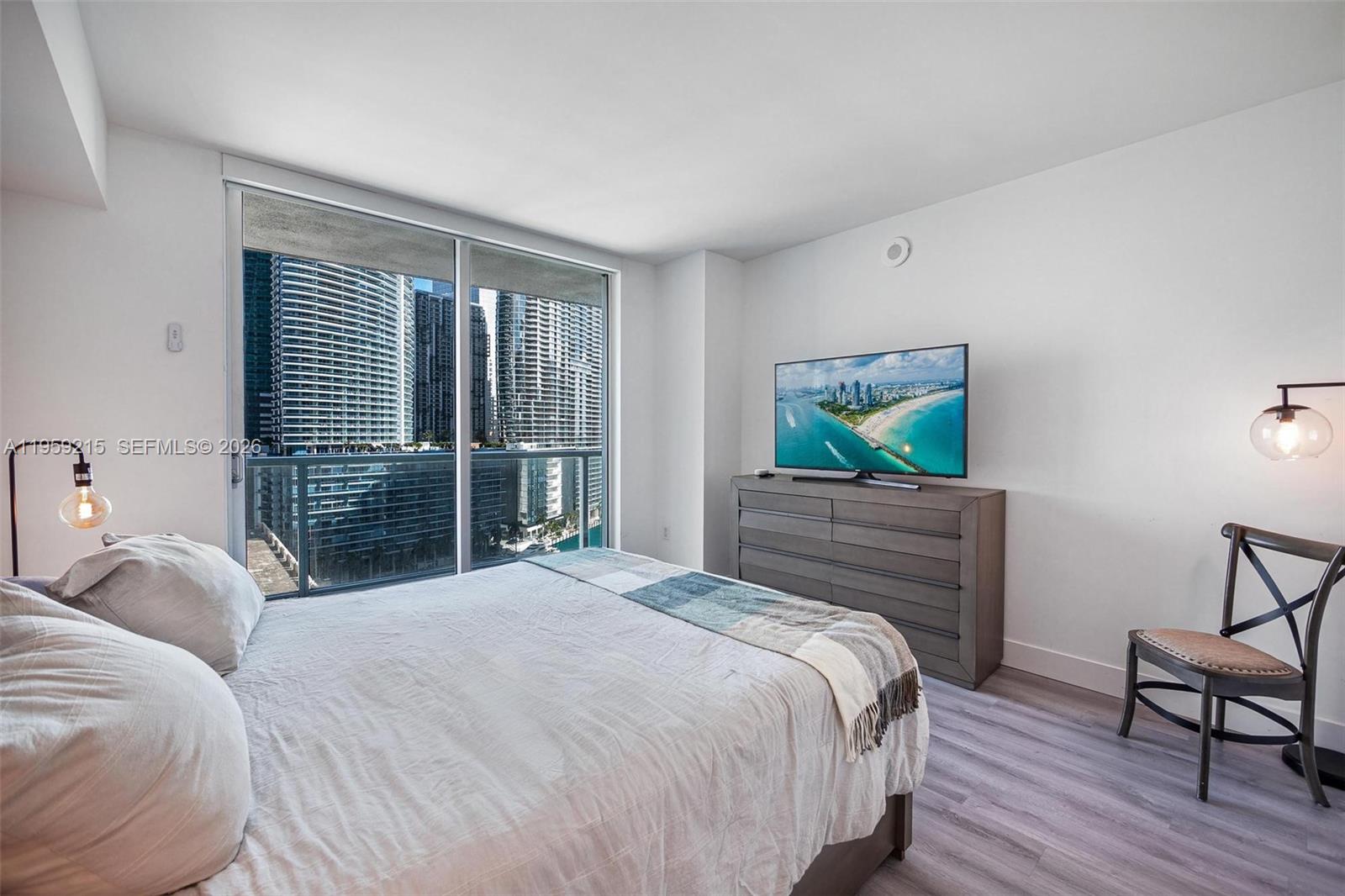 500 Brickell Avenue, Unit 1903 Miami, FL 33131 - Photo 9 of 18 a bedroom with a bed and wooden floor