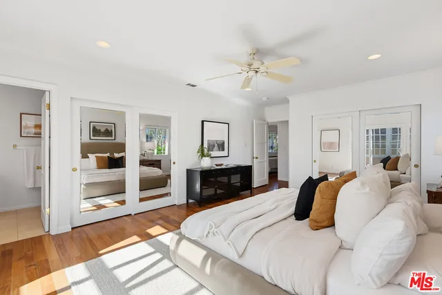a bedroom with a bed and dresser with mirror