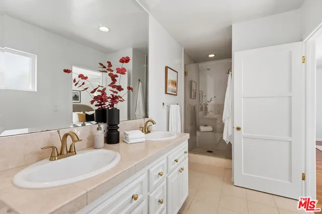 a bathroom with a double vanity sink mirror and shower