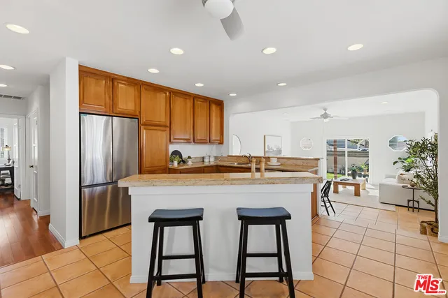 a kitchen with stainless steel appliances granite countertop table chairs sink and cabinets