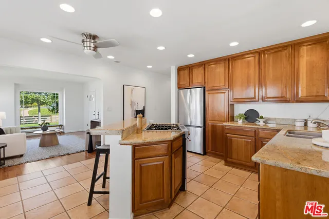 a kitchen with a stove a sink dishwasher a dining table and chairs with wooden floor