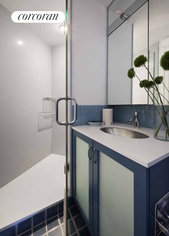 146 West 57th Street, Unit 58A Manhattan, NY 10019 - Photo 12 of 18 a bathroom with a sink and a mirror