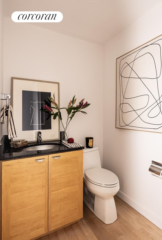 146 West 57th Street, Unit 58A Manhattan, NY 10019 - Photo 15 of 18 a bathroom with a granite countertop sink a toilet and mirror