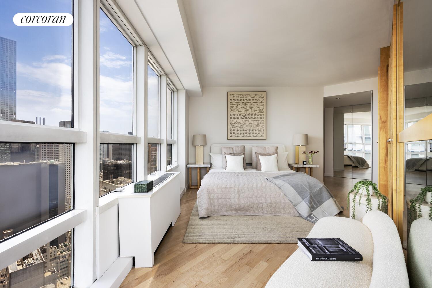 146 West 57th Street, Unit 58A Manhattan, NY 10019 - Photo 7 of 18 a bedroom with a large bed and a large window