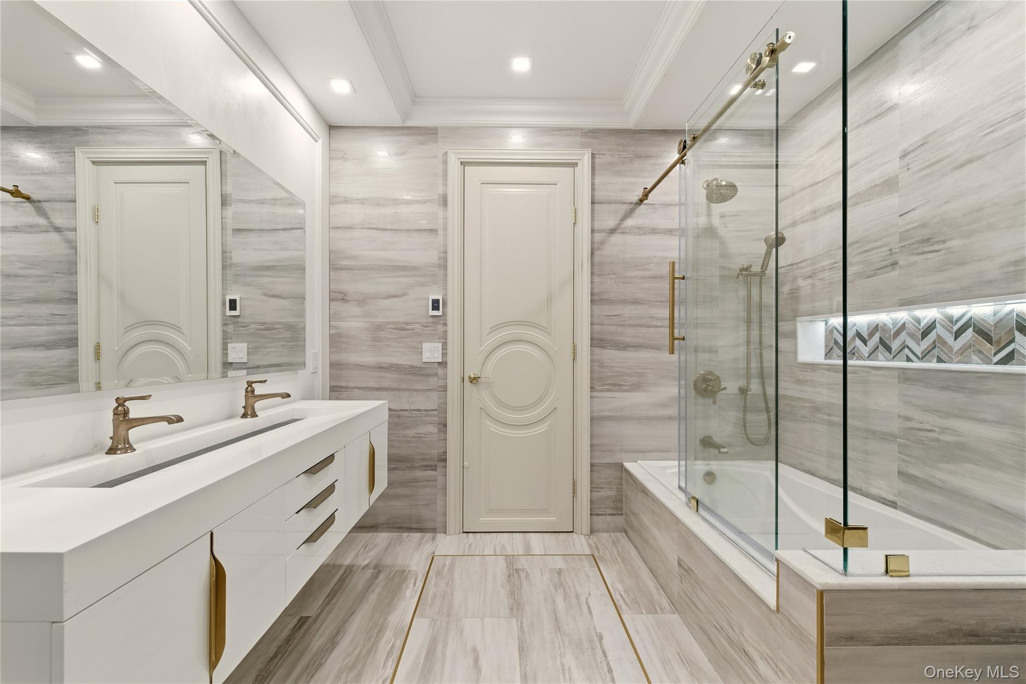 55 Coves Run Syosset, NY 11791 - Photo 31 of 50 a bathroom with a double vanity sink a mirror and a bathtub