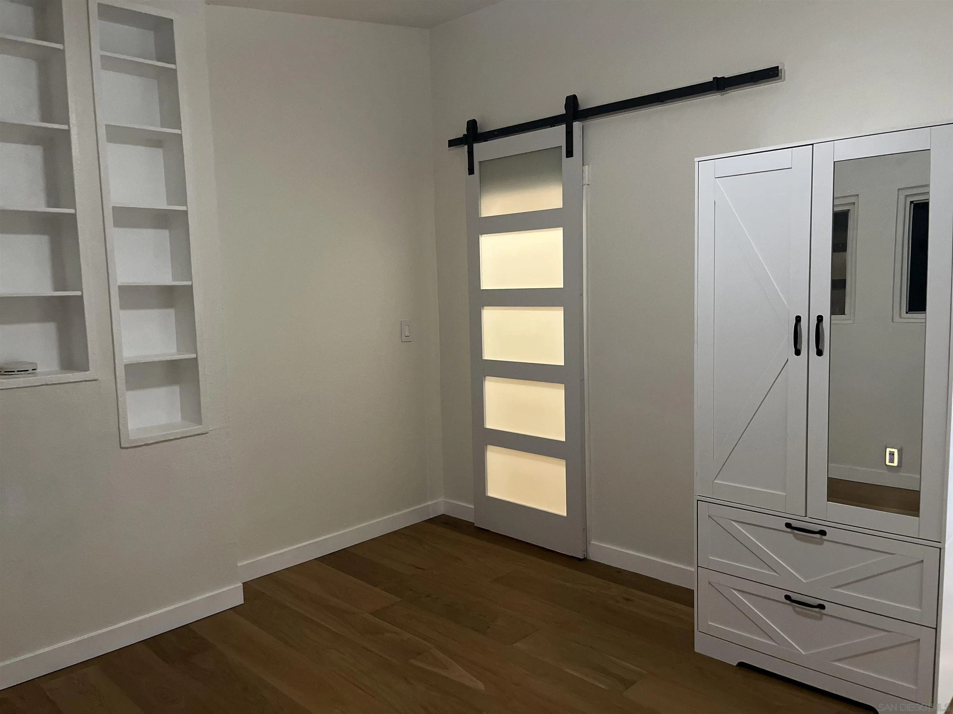 2331 Shamrock Street, Unit STUDIO San Diego, CA 92105 - Photo 12 of 13 a view of an empty room with wooden floor and a window