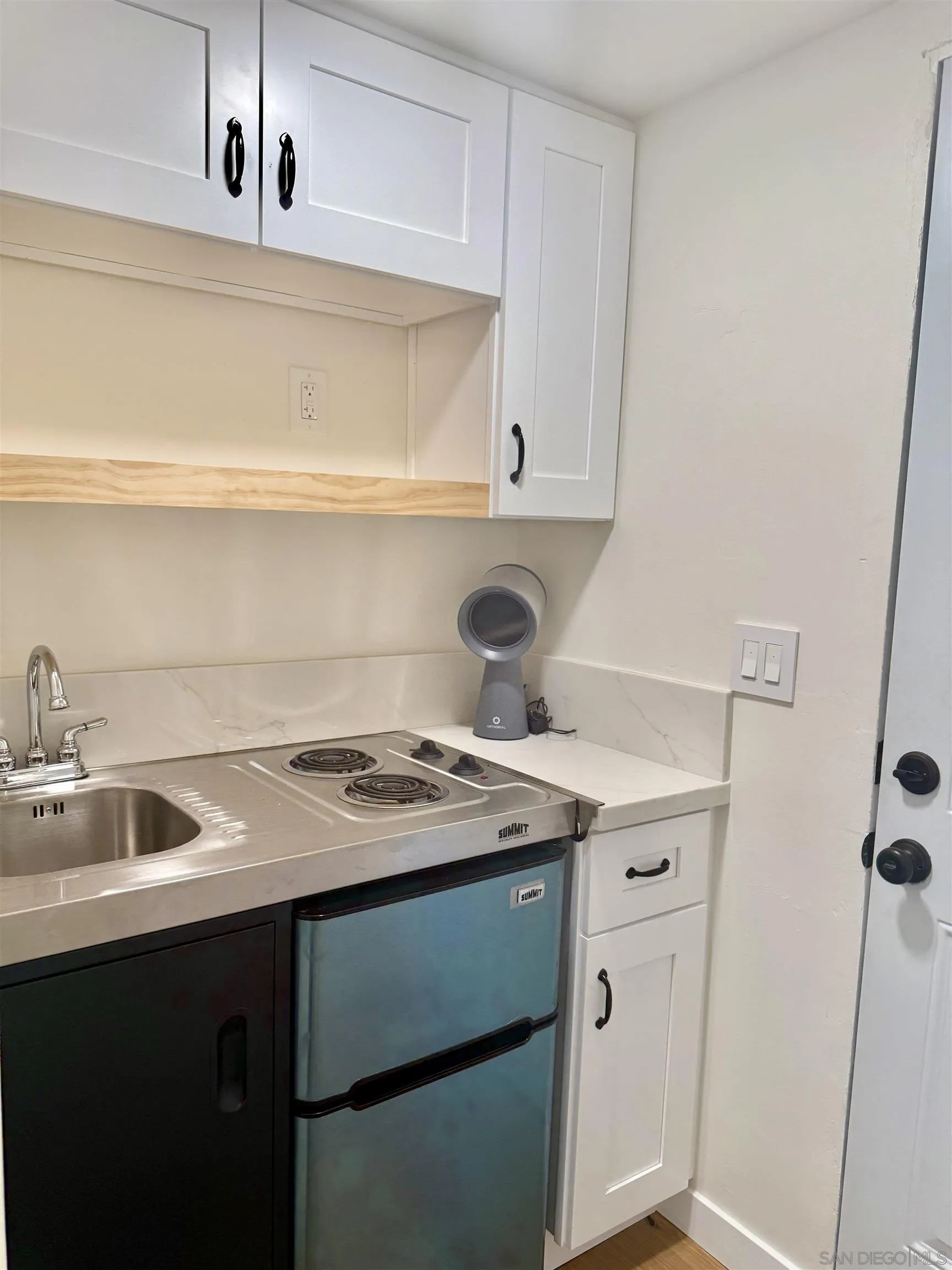 2331 Shamrock Street, Unit STUDIO San Diego, CA 92105 - Photo 10 of 13 a kitchen with a sink a stove and cabinets