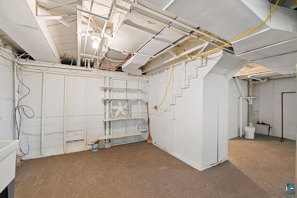 122 3rd Street Cloquet, MN 55720 - Photo 26 of 42 Unfinished basement featuring exposed joists, visible ductwork, and built-in shelving