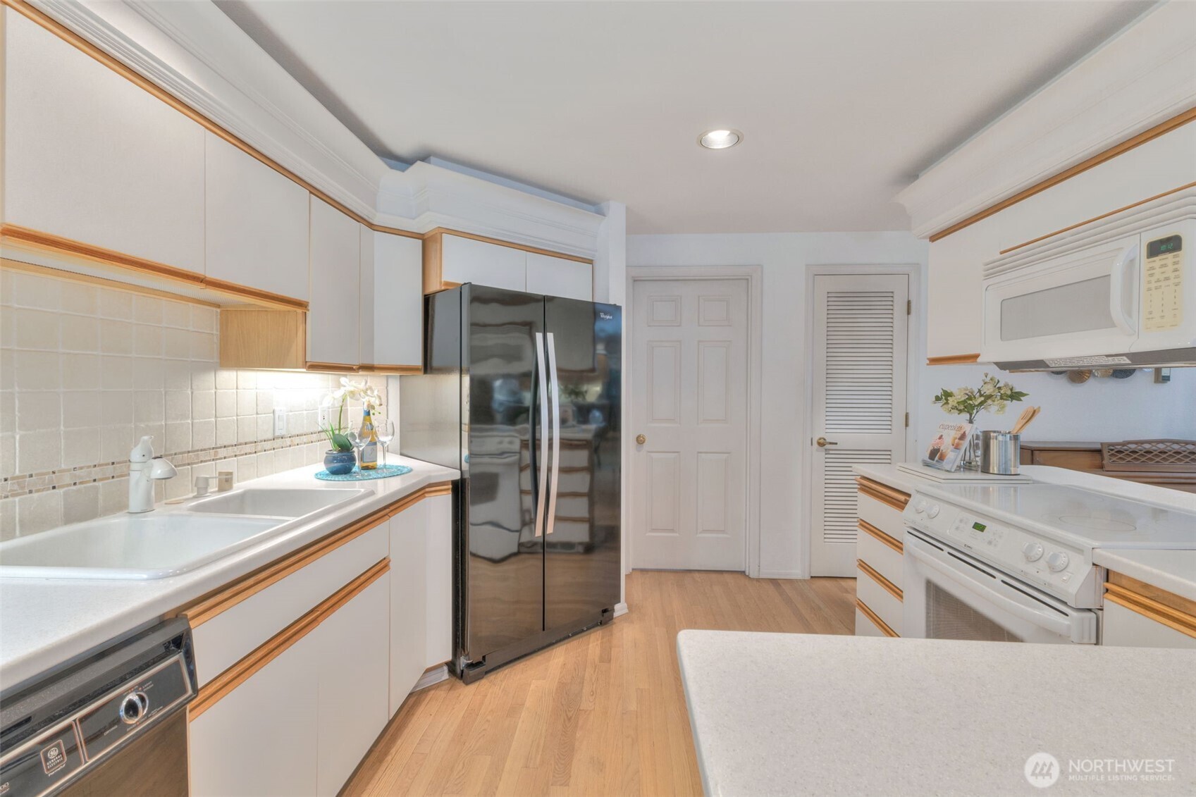 311 Keach Loop Steilacoom, WA 98388 - Photo 14 of 38 a kitchen with a sink stove and refrigerator