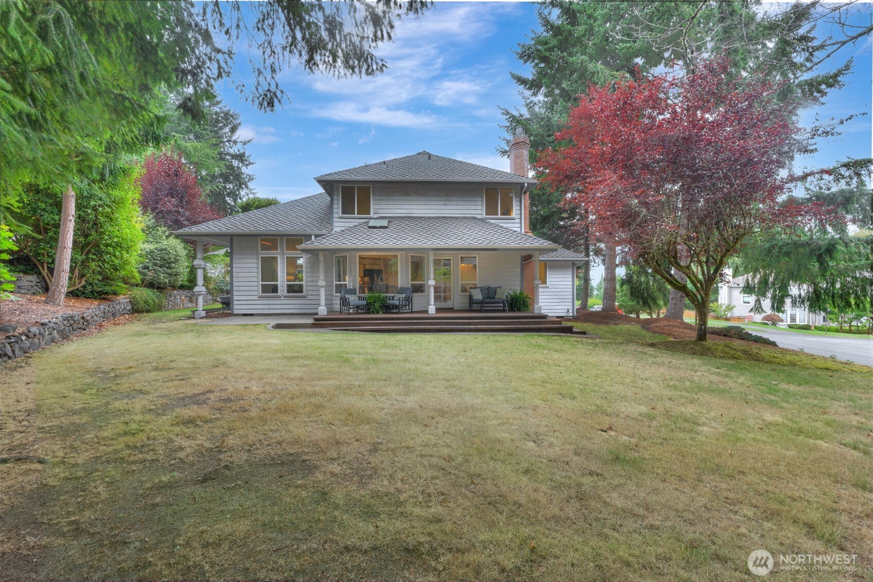 311 Keach Loop Steilacoom, WA 98388 - Photo 33 of 38 a front view of a house with large trees and a yard