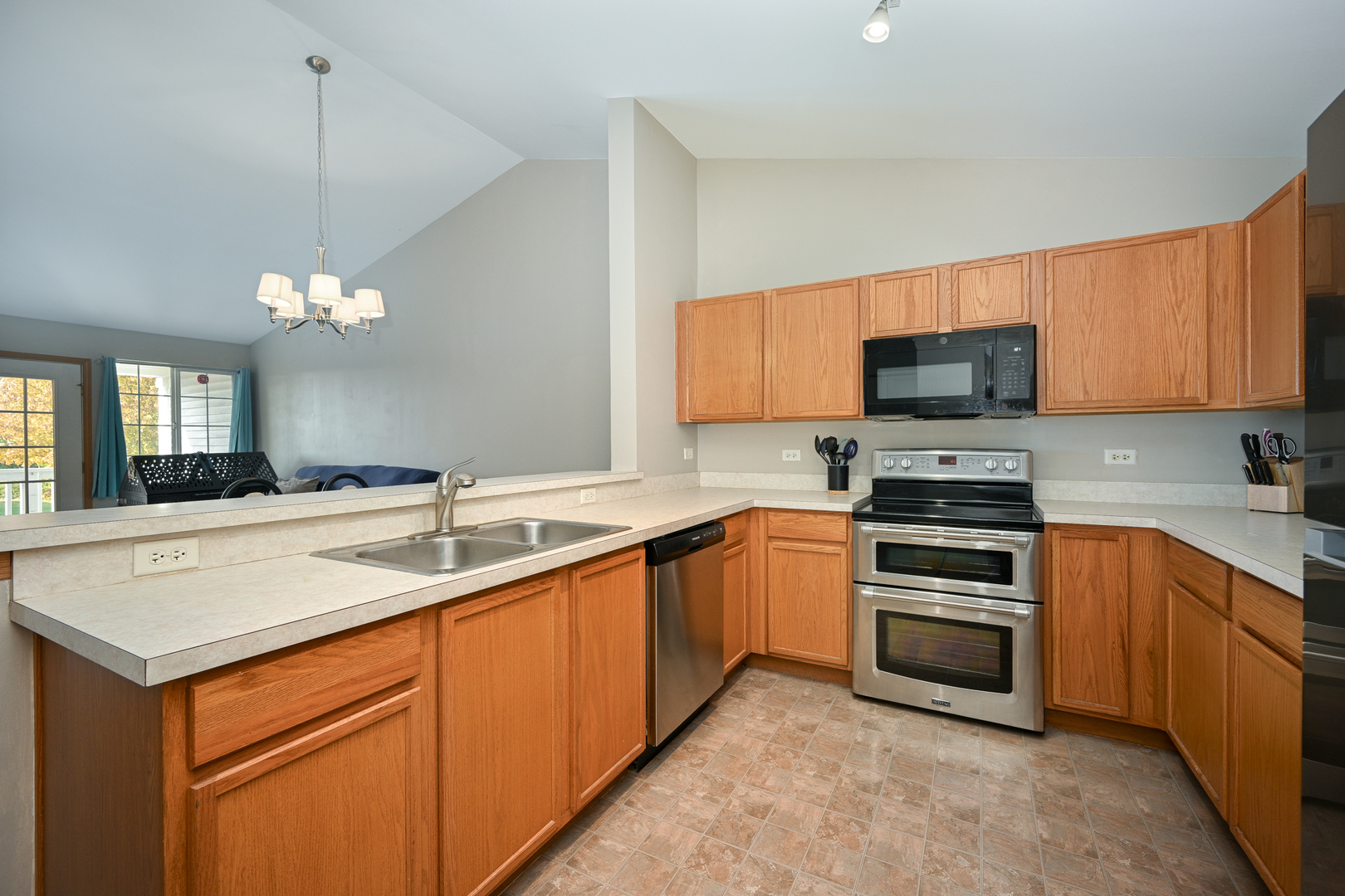 1425 McClure Road, Unit 1425 Aurora, IL 60505 - Photo 5 of 12 a kitchen with stainless steel appliances granite countertop a sink stove and microwave