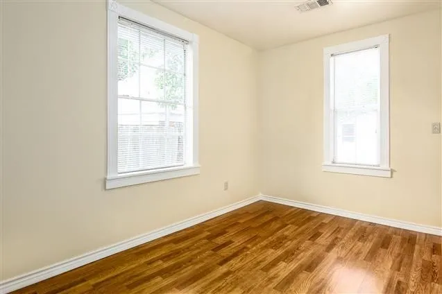 a view of a room with wooden floor and windows
