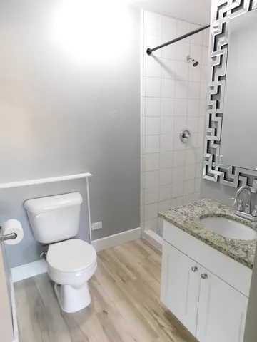 a bathroom with a granite countertop sink toilet and shower