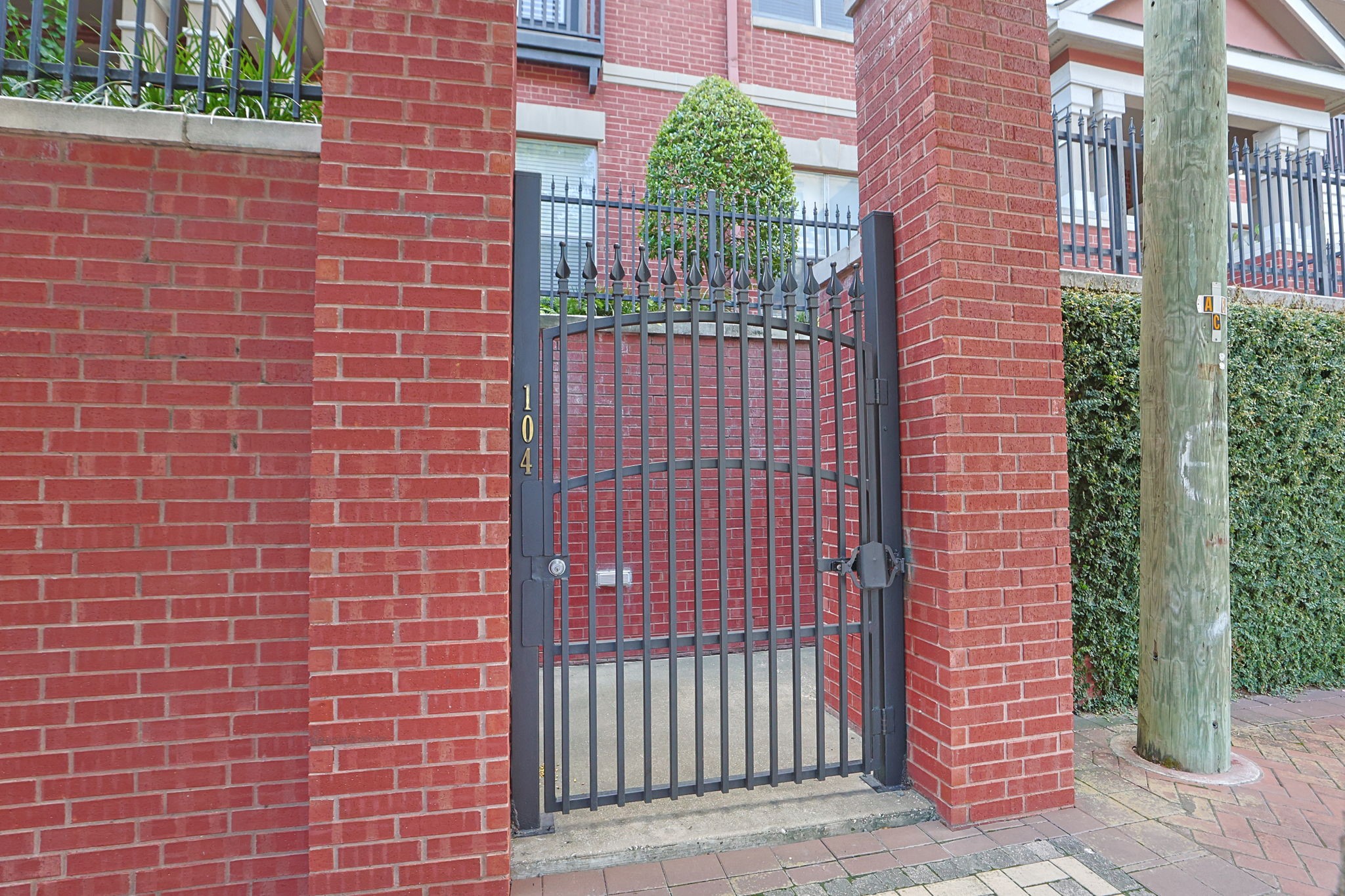 2400 South McCue Road, Unit 104 Houston, TX 77056 - Photo 4 of 38 Charming condo entrance located on McCue Street, offering a welcoming pedestrian gate right from the sidewalk.