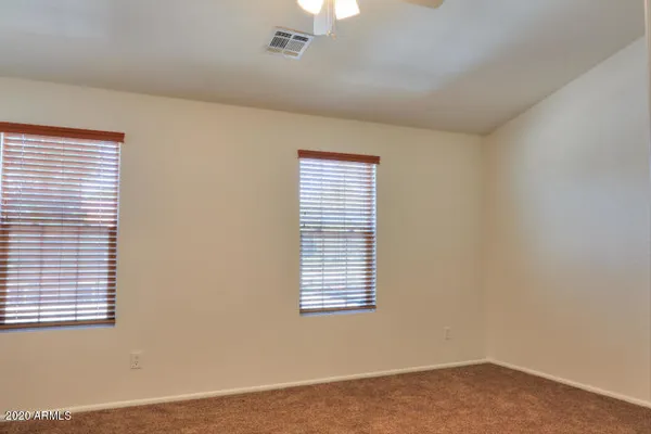 a view of an empty room with window and closet area