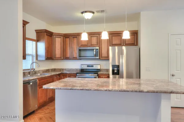 a kitchen with stainless steel appliances granite countertop a sink a stove and a refrigerator