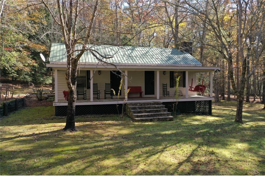 2320 Hardman Road Clarkesville, GA 30523 - Photo 25 of 53 a view of a swimming pool with couches and a table and chairs under an umbrella