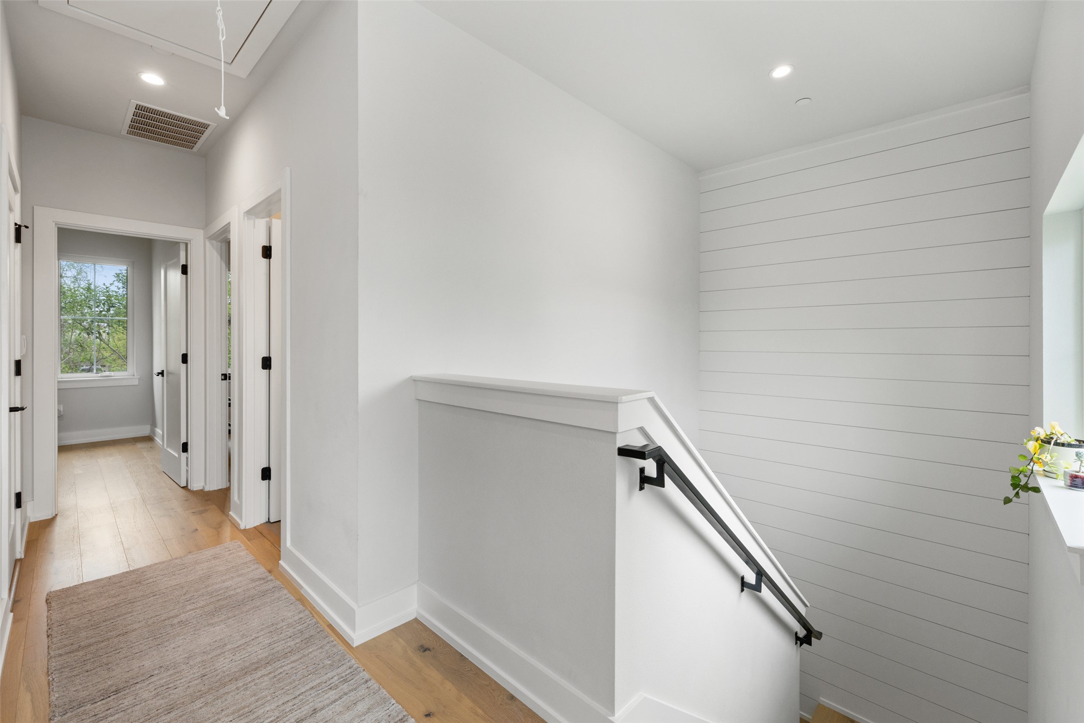 1504 Ruth Avenue, Unit 3 Austin, TX 78757 - Photo 26 of 39 Clean lines and light wood flooring define this inviting hallway, featuring a stylish staircase with a modern railing.