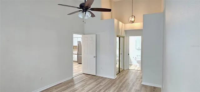 a view of a room with wooden floor and a ceiling fan