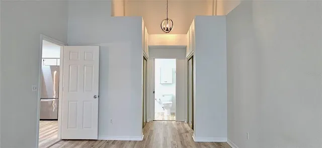 a view of a hallway with wooden floor and a cabinet