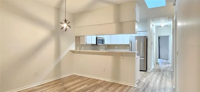 a view of a refrigerator in kitchen and an empty room