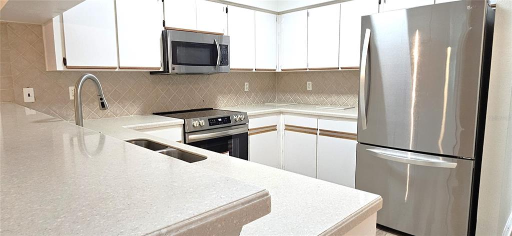 2736 Penzance Street Palm Harbor, FL 34684 - Photo 9 of 27 a kitchen with a refrigerator sink and stove top oven