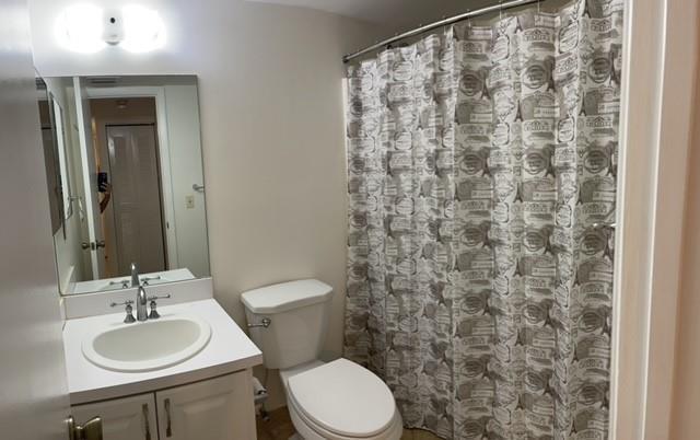 6760 Palmetto Circle South, Unit 102 Boca Raton, FL 33433 - Photo 3 of 5 a bathroom with a granite countertop sink toilet and a mirror