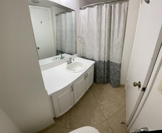 6760 Palmetto Circle South, Unit 102 Boca Raton, FL 33433 - Photo 4 of 5 a bathroom with a sink a mirror and a shower curtain