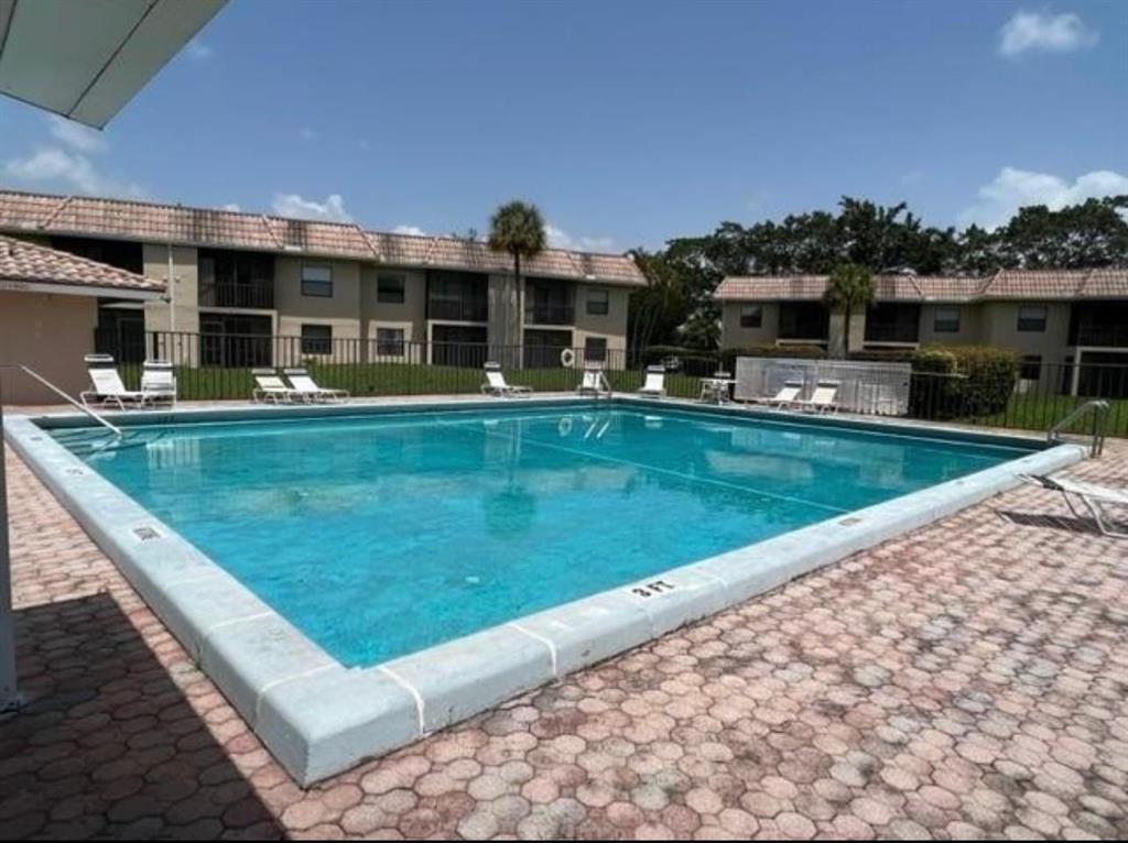 6760 Palmetto Circle South, Unit 102 Boca Raton, FL 33433 - Photo 5 of 5 a front view of a house with a garden and balcony