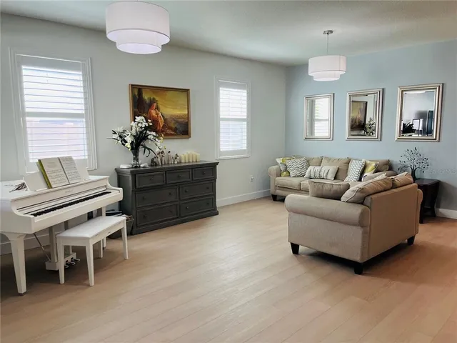 a living room with furniture a potted plant and a dresser