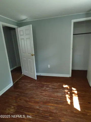 a view of empty room with wooden floor