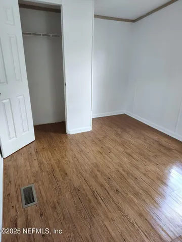 a view of a livingroom with wooden floor and staircase
