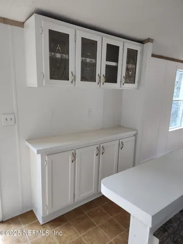 a white house that has a tree in front of it