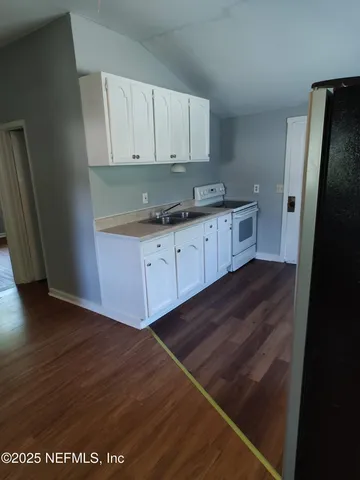 a kitchen with granite countertop a refrigerator and a sink