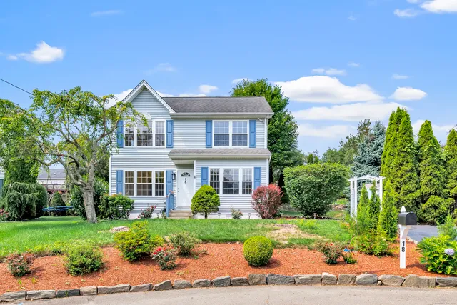 a front view of a house with a yard and potted plants