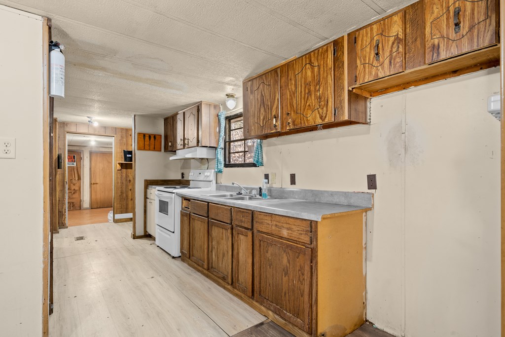7589 Tails Creek Road Ellijay, GA 30540 - Photo 33 of 44 a kitchen with a sink cabinets stainless steel appliances and a window