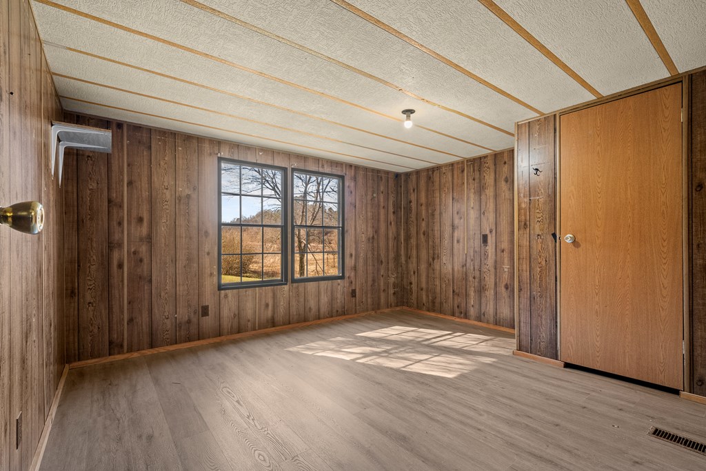 7589 Tails Creek Road Ellijay, GA 30540 - Photo 38 of 44 an empty room with wooden floor and windows
