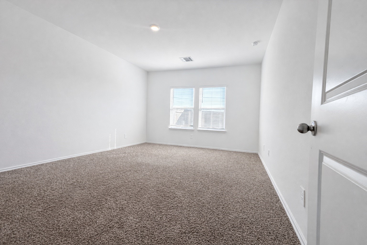 1739 Royal Rim Drive Houston, TX 77014 - Photo 10 of 20 This primary room features neutral walls and a cozy carpeted floor, with ample natural light from two windows, creating a bright and welcoming space.