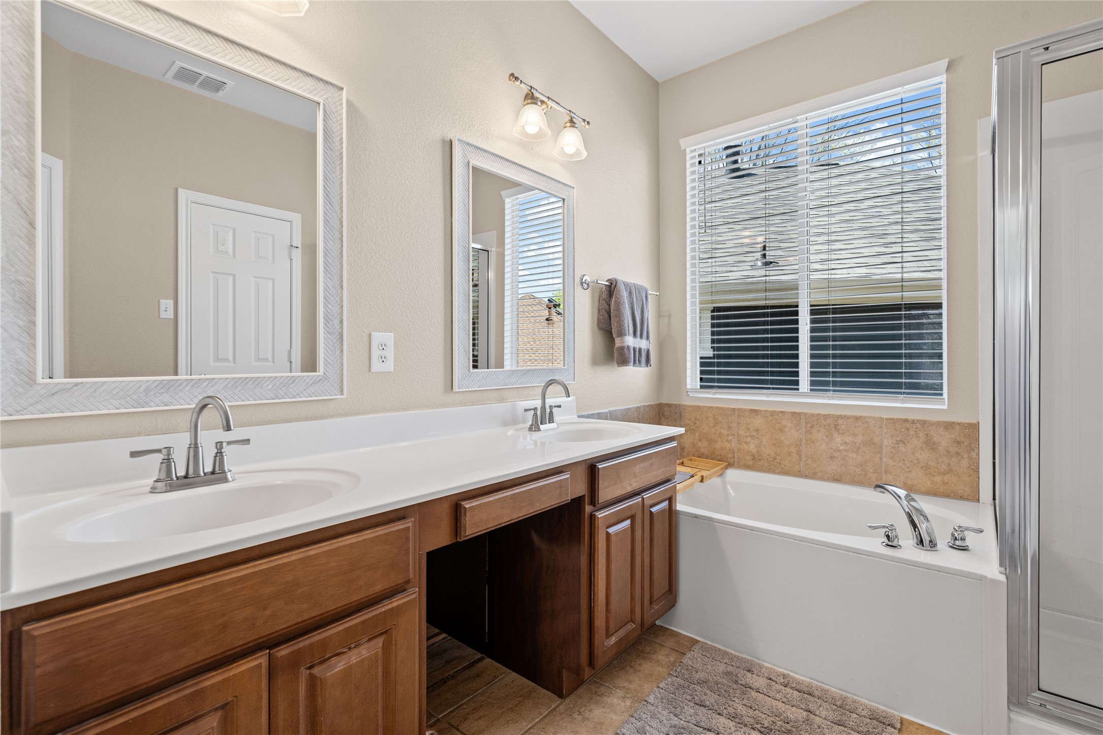 411 West St Elmo Road, Unit 24 Austin, TX 78745 - Photo 17 of 29 Bathroom featuring double vanity, a bath, a stall shower, and light tile patterned floors