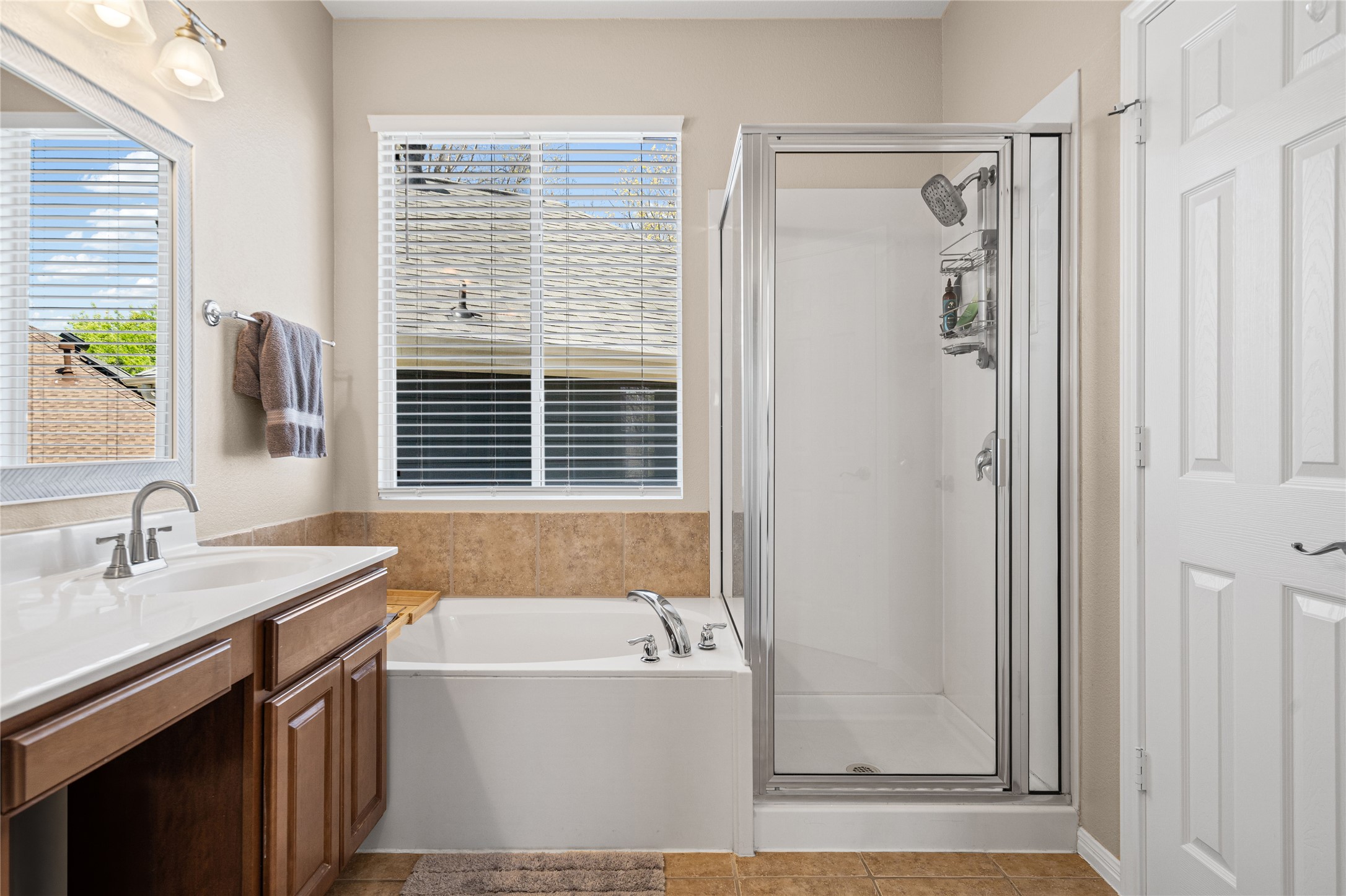 411 West St Elmo Road, Unit 24 Austin, TX 78745 - Photo 18 of 29 Full bathroom featuring vanity, a shower stall, a garden tub, and light tile patterned floors