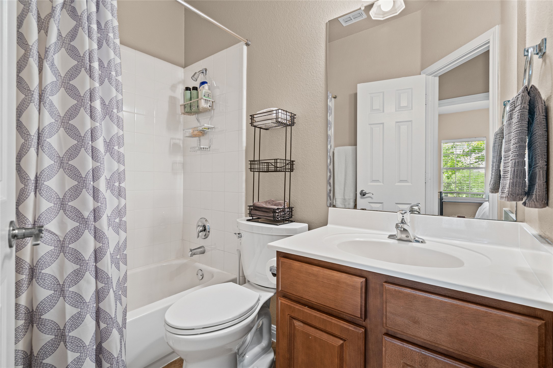 411 West St Elmo Road, Unit 24 Austin, TX 78745 - Photo 24 of 29 Full bath with vanity, a textured wall, and shower / bath combo