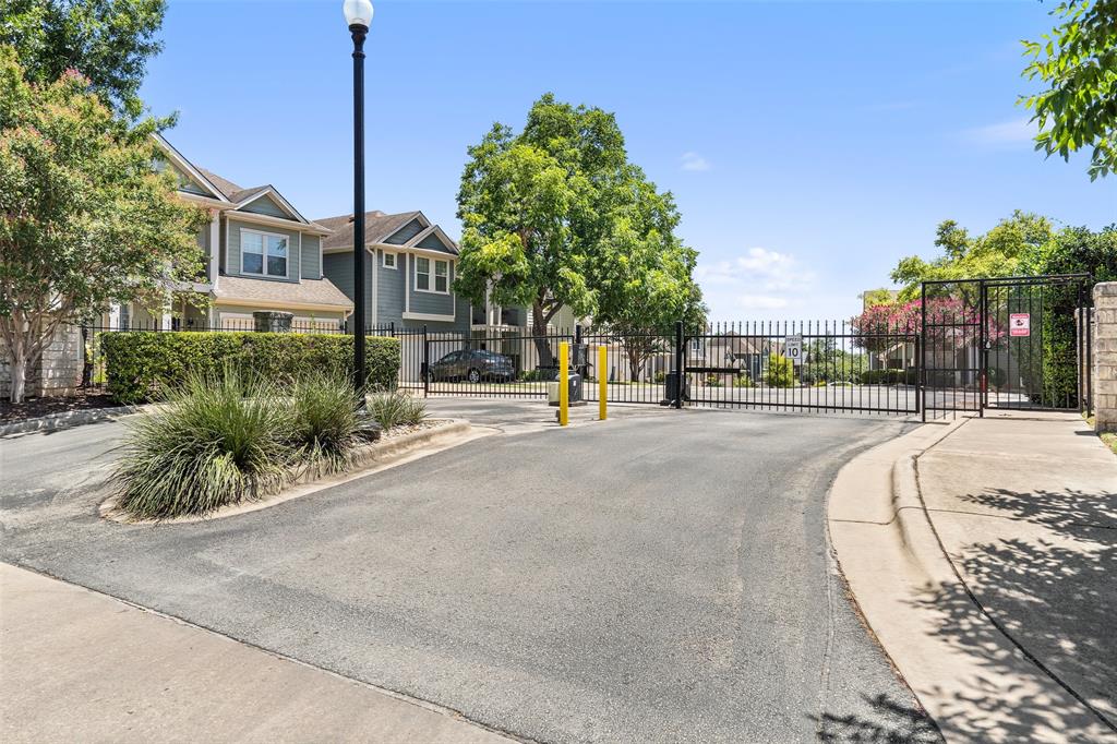 411 West St Elmo Road, Unit 24 Austin, TX 78745 - Photo 28 of 29 View of asphalt road with sidewalks, a gate, a gated entry, and curbs