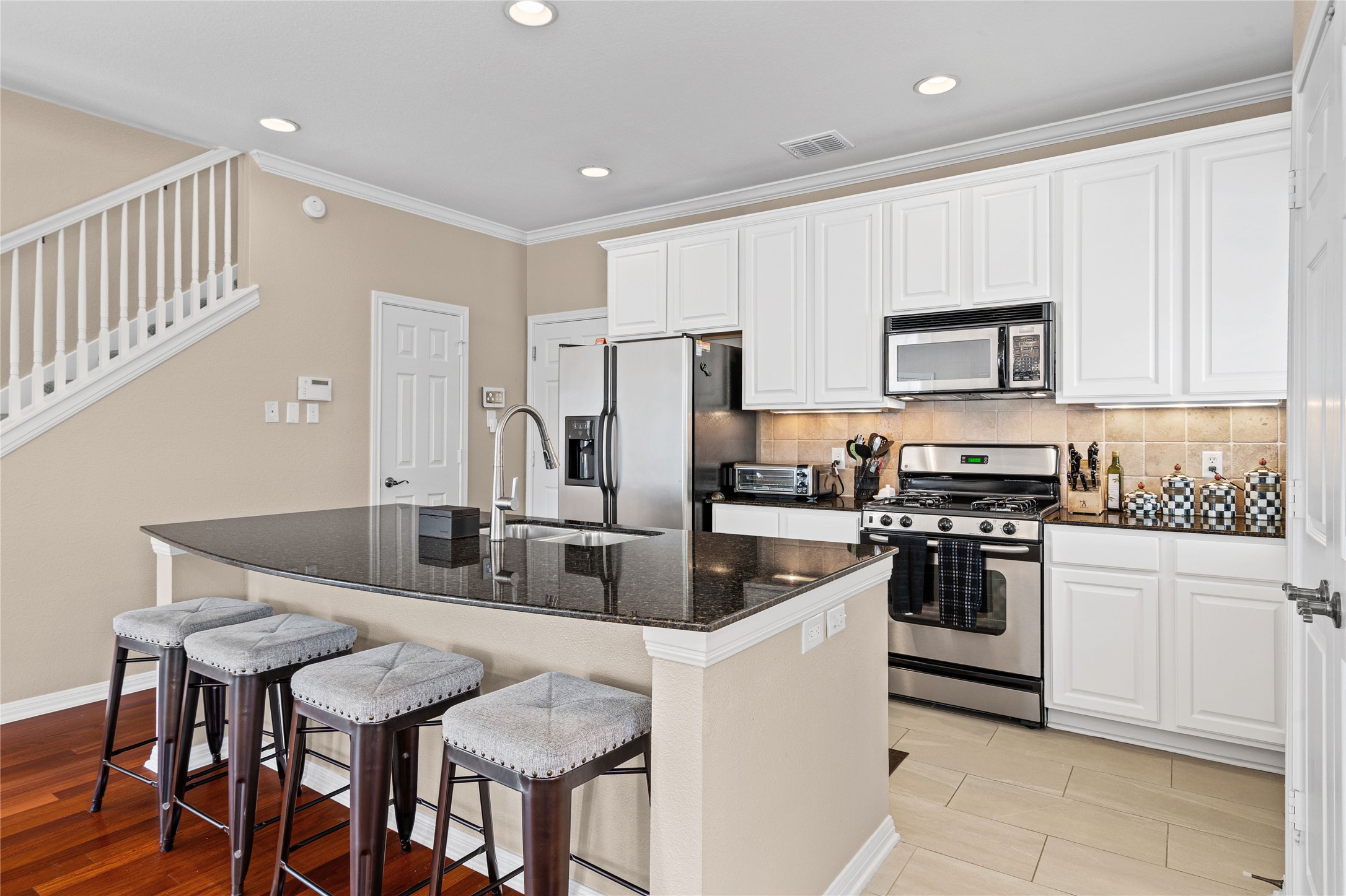 411 West St Elmo Road, Unit 24 Austin, TX 78745 - Photo 6 of 29 a kitchen with stainless steel appliances granite countertop a stove a sink a microwave a refrigerator and white cabinets