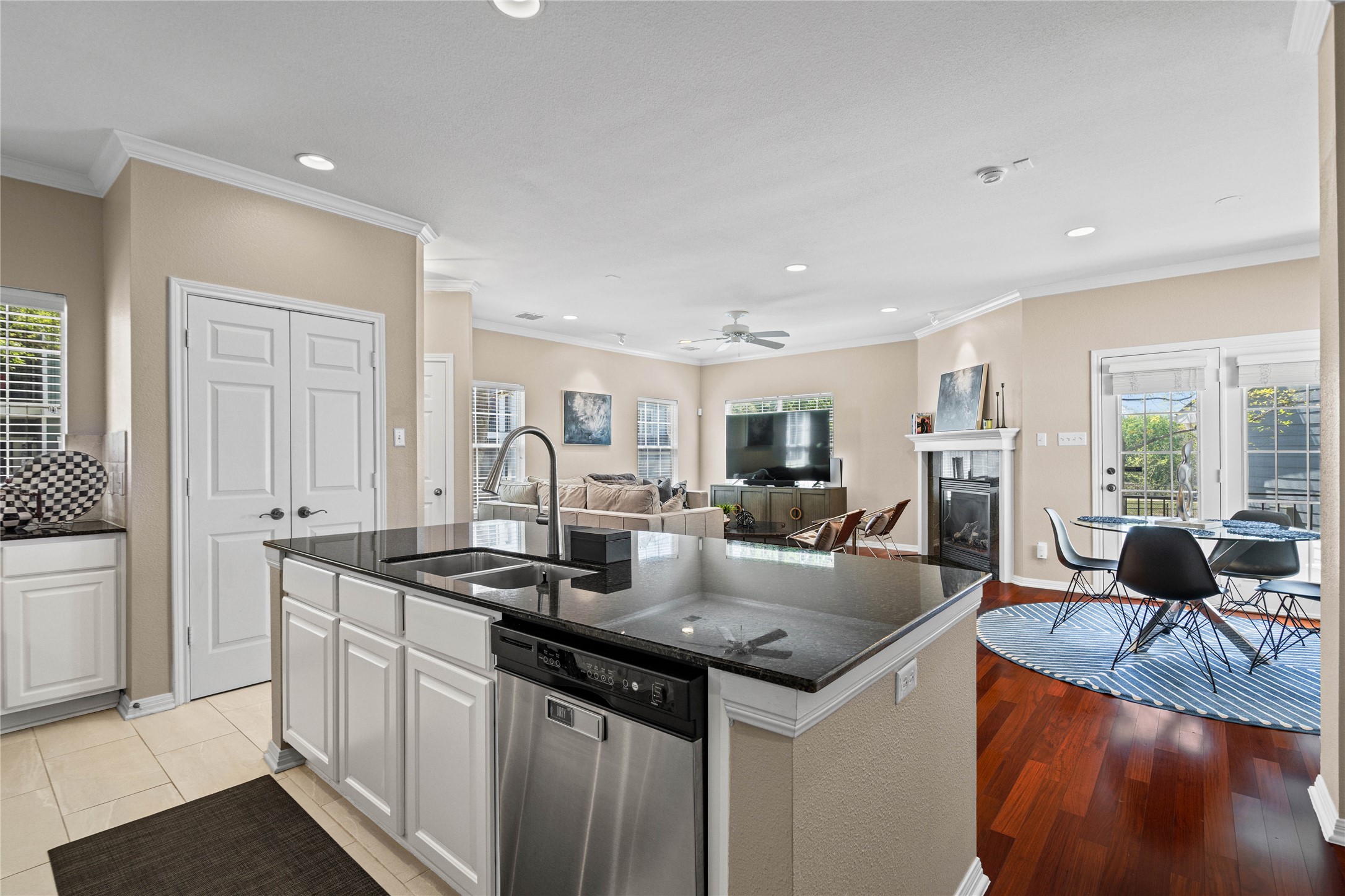 411 West St Elmo Road, Unit 24 Austin, TX 78745 - Photo 29 of 29 Kitchen with an island with sink, stainless steel dishwasher, open floor plan, healthy amount of natural light, and crown molding