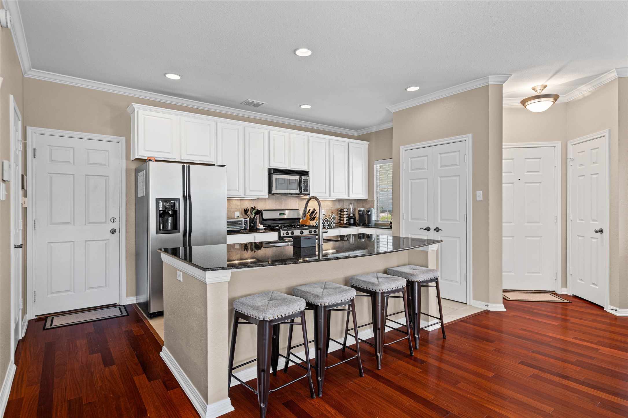 411 West St Elmo Road, Unit 24 Austin, TX 78745 - Photo 7 of 29 a kitchen with stainless steel appliances a dining table chairs microwave and refrigerator