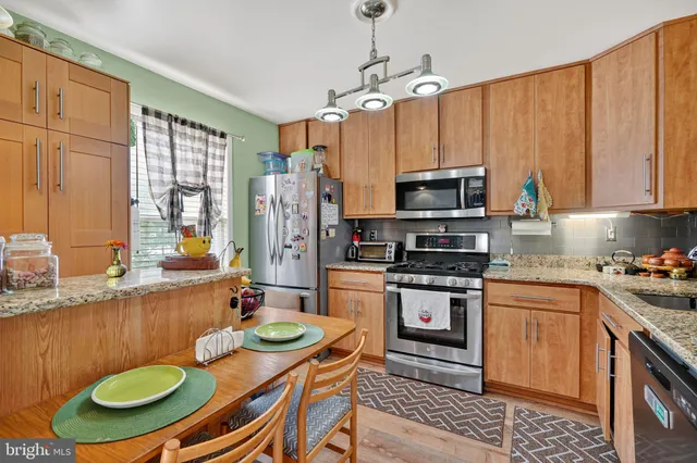 a kitchen with stainless steel appliances a stove a sink and a refrigerator
