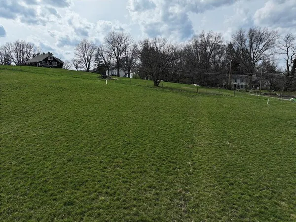 a view of a field with ocean in background