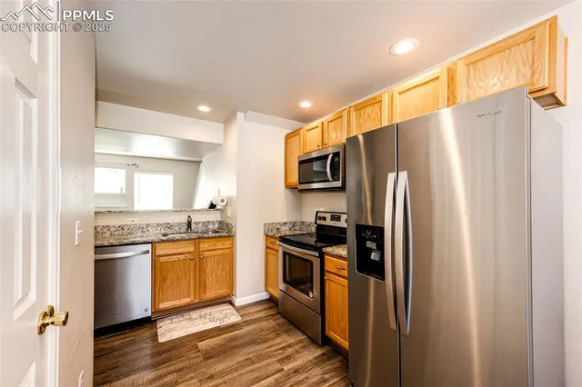 a kitchen with stainless steel appliances granite countertop a refrigerator a stove top oven a sink and dishwasher